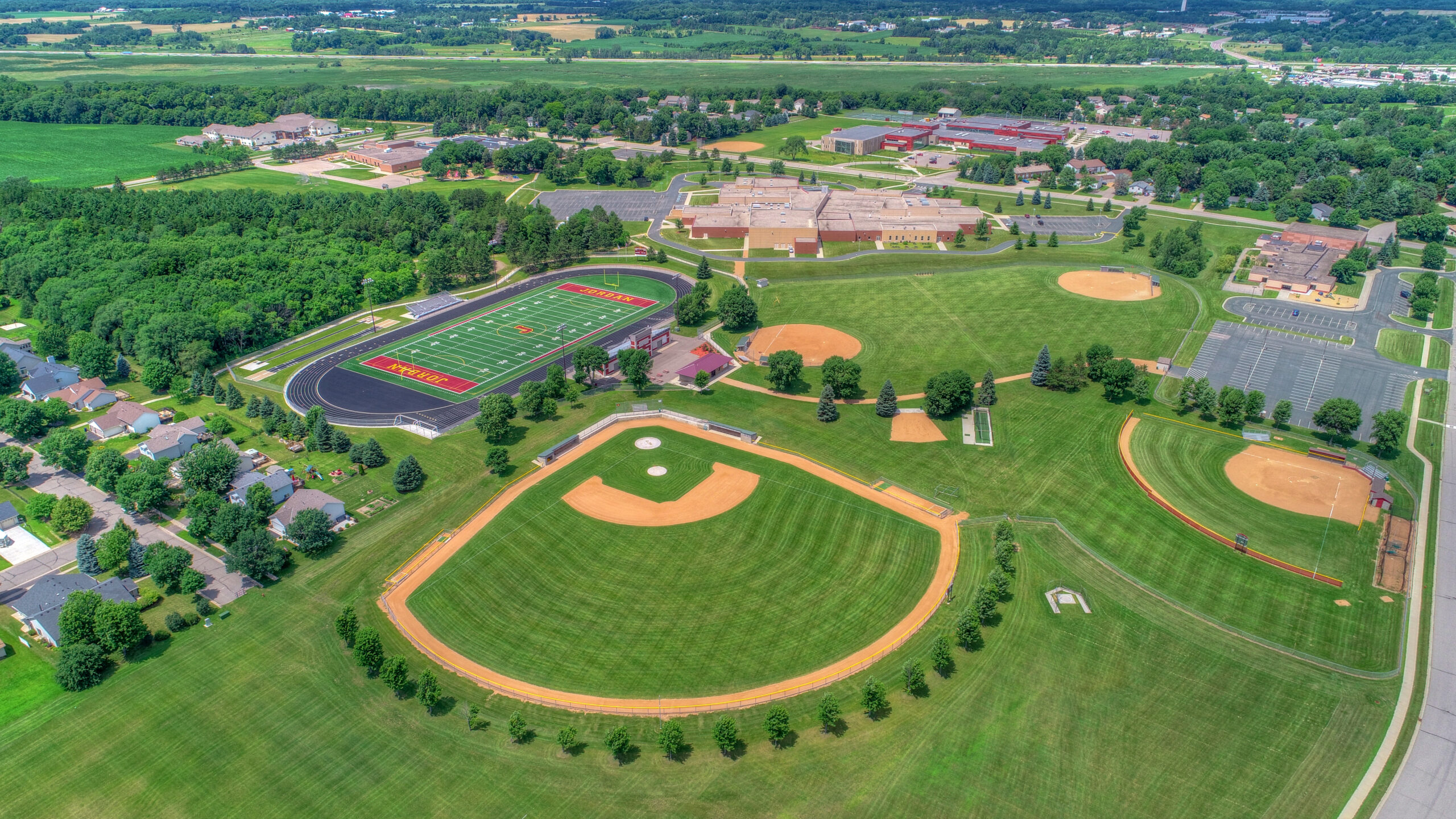 Aerial drone photo of Jordan High School athletic complex including baseball fields, football stadium, and school building